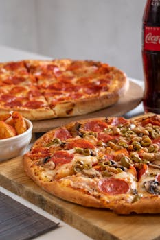Close-up of pepperoni and veggie pizzas with soda, perfect for a casual dining experience.