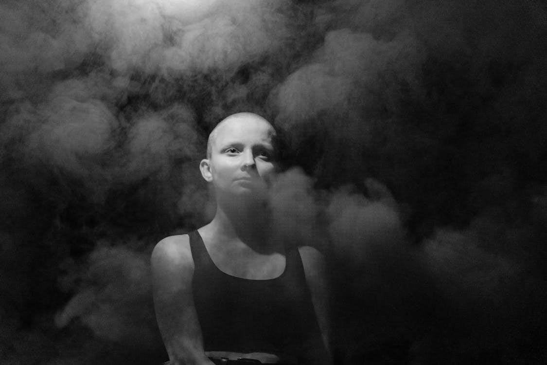 Grayscale Photo of Woman in Tank Top on Smoke 