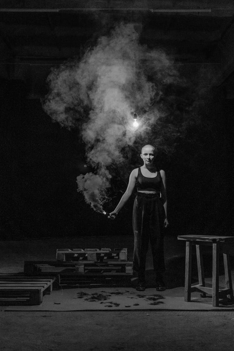 A Grayscale Of A Woman Holding A Flare