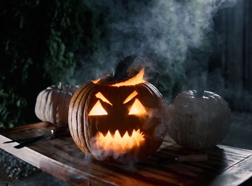 Free Glowing jack-o'-lantern with smoke, perfect for Halloween night ambiance. Stock Photo