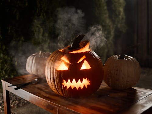 Free Close-Up Shot of Jack O Lantern on a Wooden Table Stock Photo