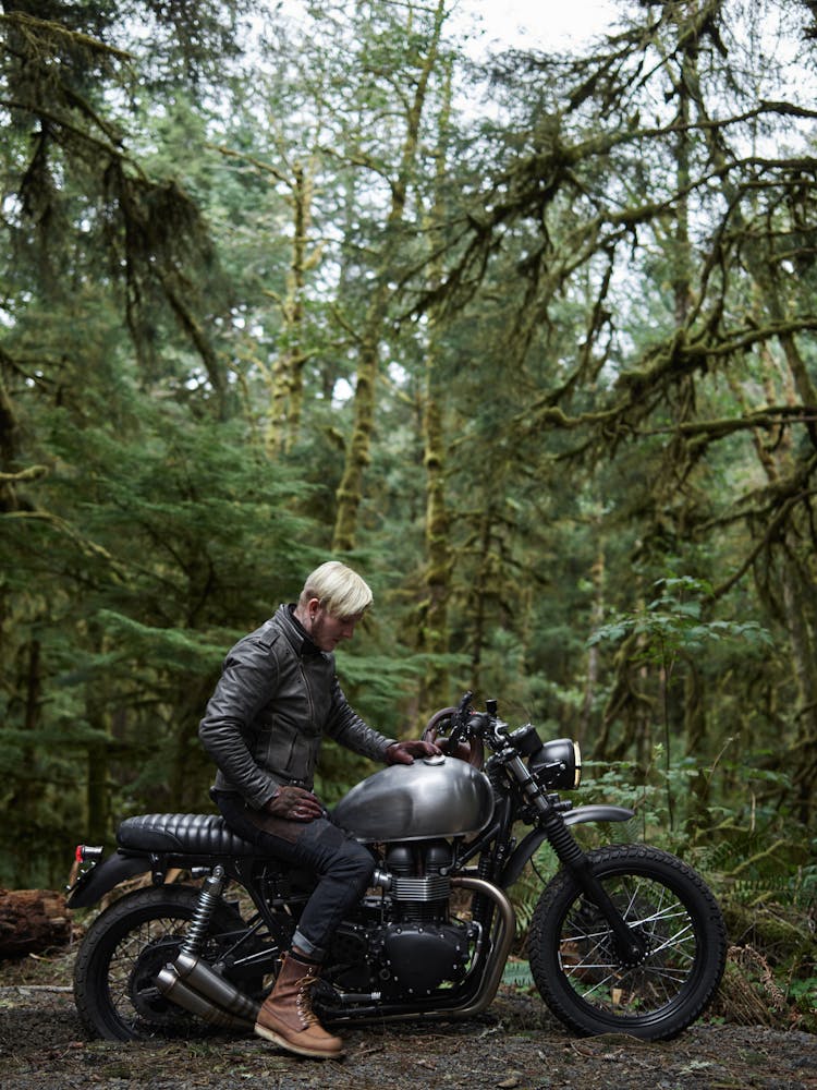 Man In Black Leather Jacket Riding Motorcycle In Forest