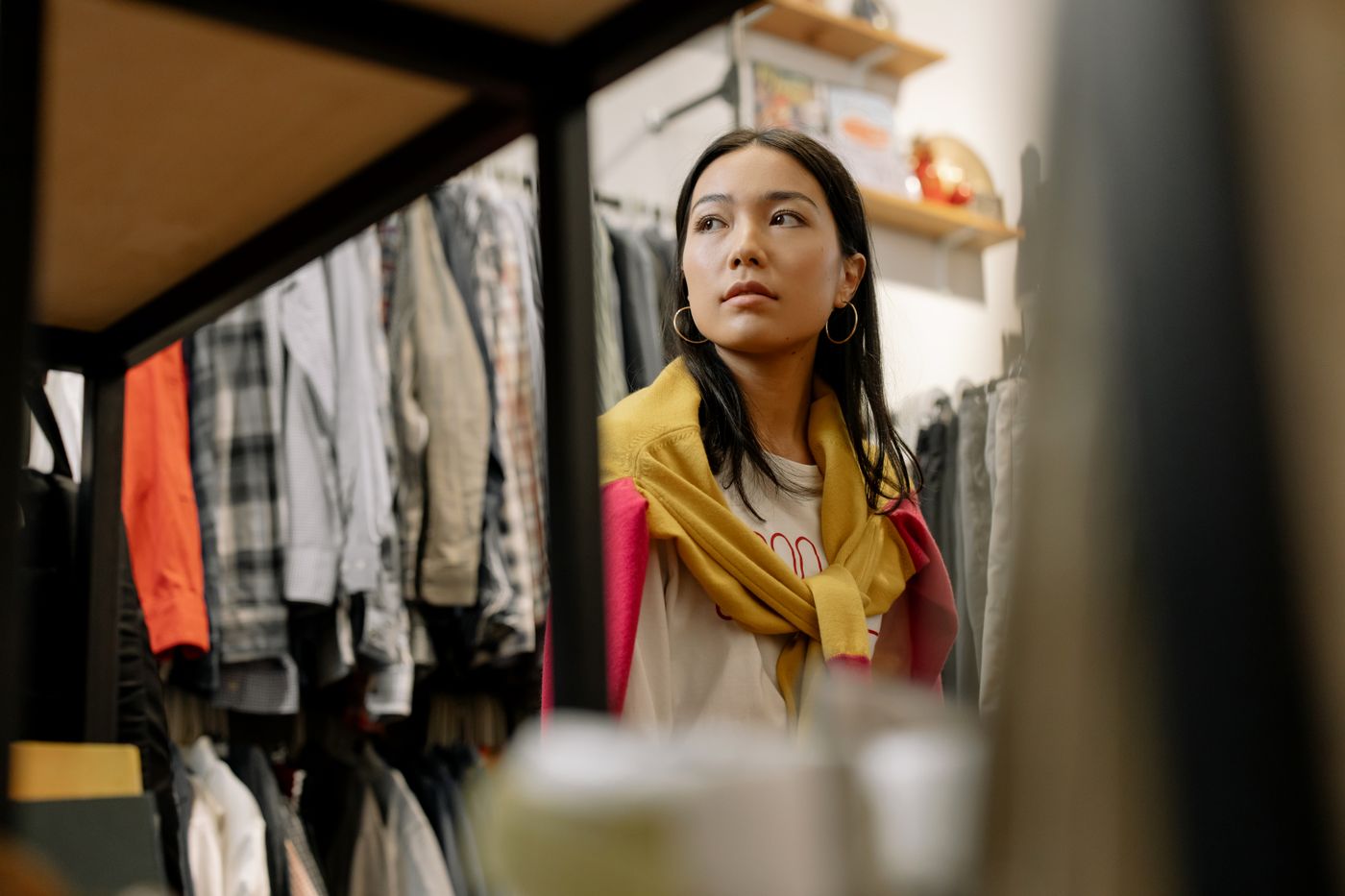 A clothing shop owner looking through racks of garments