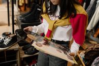 Woman in White and Red Long Sleeve Shirt and Blue Denim Jeans Holding White and Red