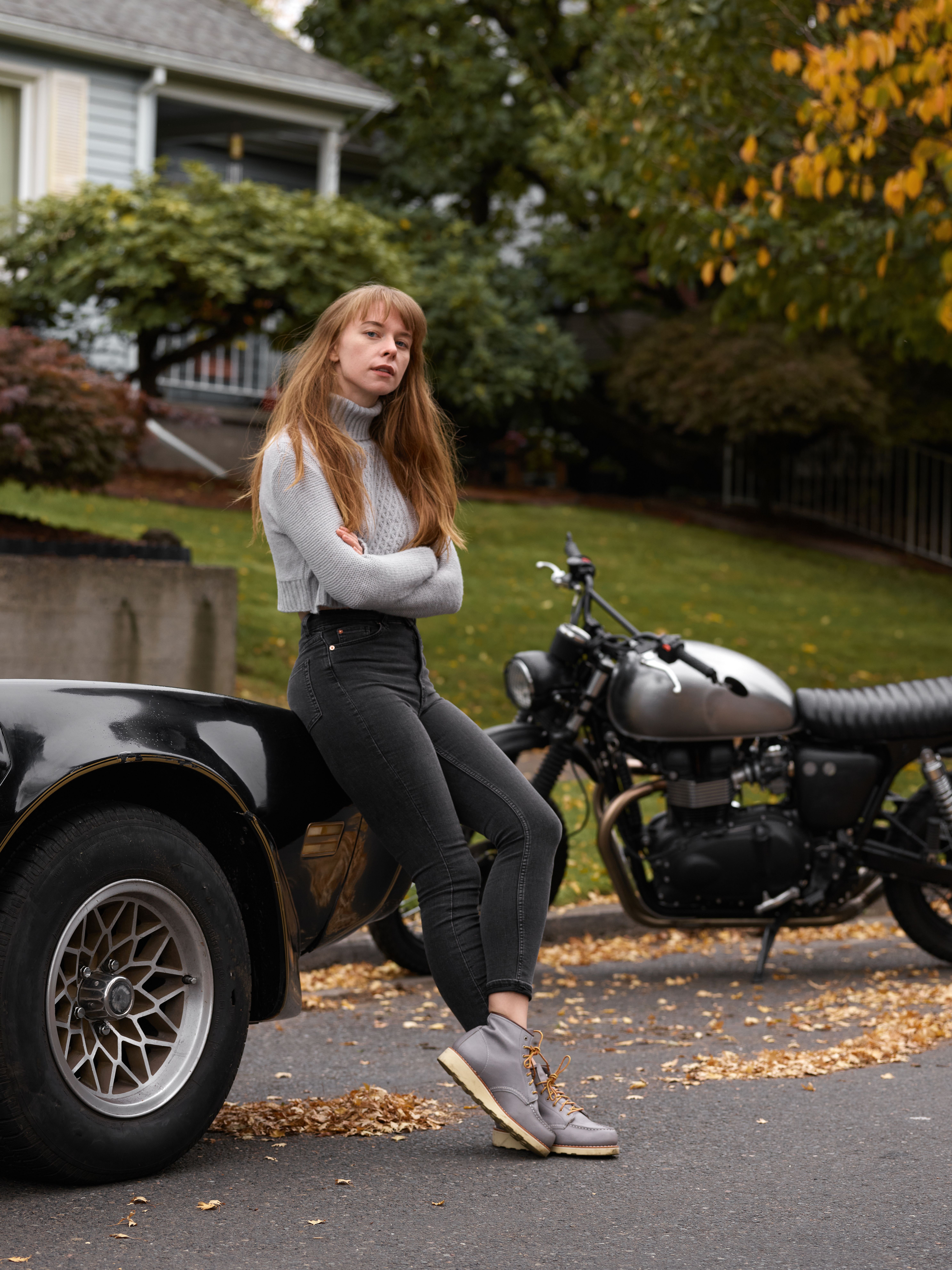 Woman in White Long Sleeve Shirt and Black Denim Jeans Leaning on Black ...