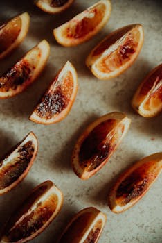 Close-up of ripe blood orange slices arranged on a rustic surface, capturing vibrant colors and textures.