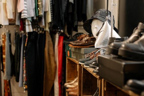 Free Clothing store interior featuring diverse apparel, shoes, and accessories on display. Stock Photo