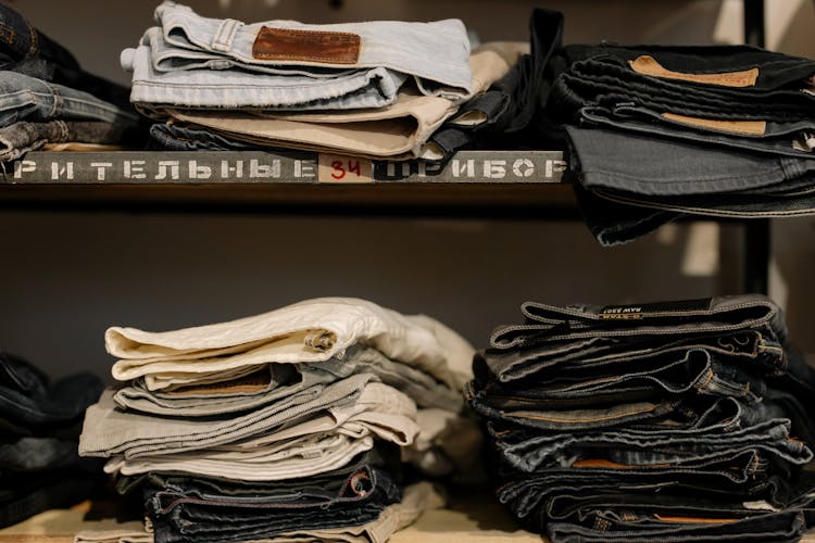 Stack Of Folded Denim Pants On The Shelves