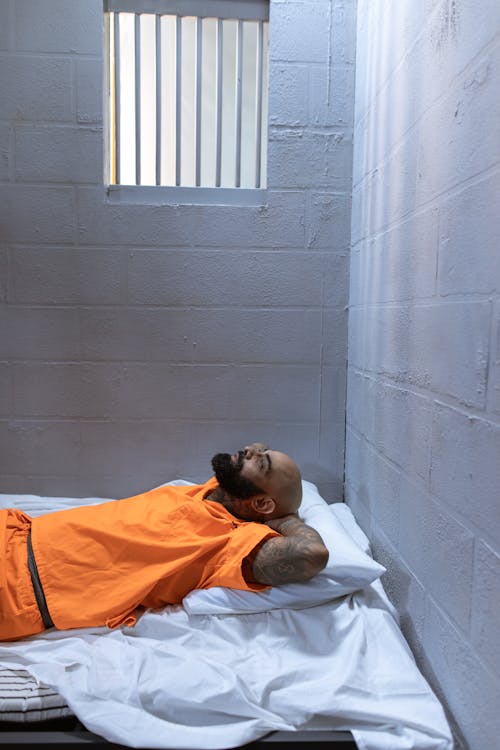 Free A Prisoner Lying on His Cell Bed Stock Photo