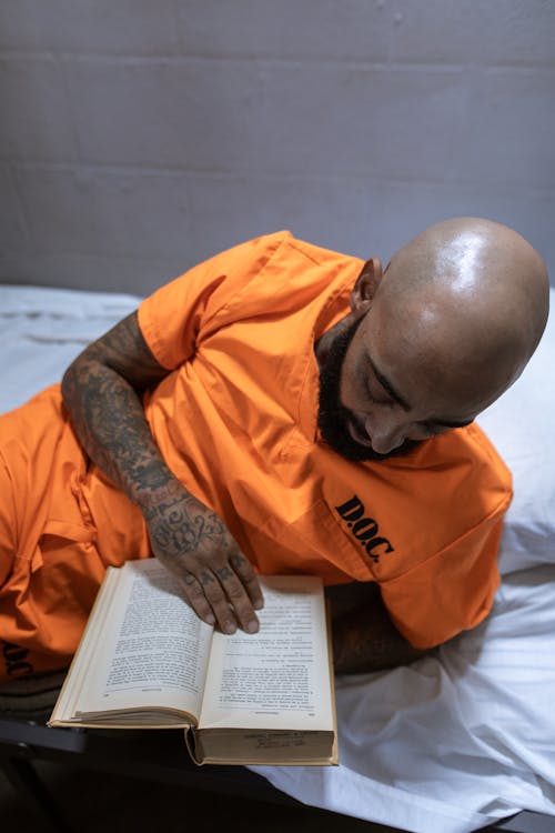 Gratis Hombre De Libro De Lectura De Camisa Naranja Foto de stock