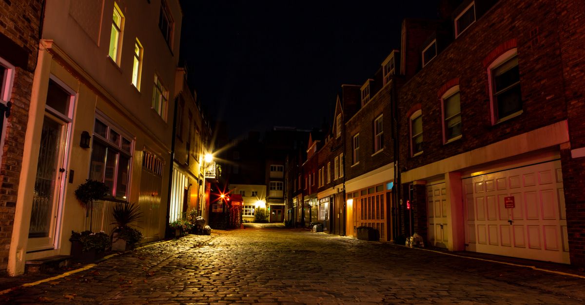 Serene cobblestone alley in London with warm lighting highlighting historic architecture.