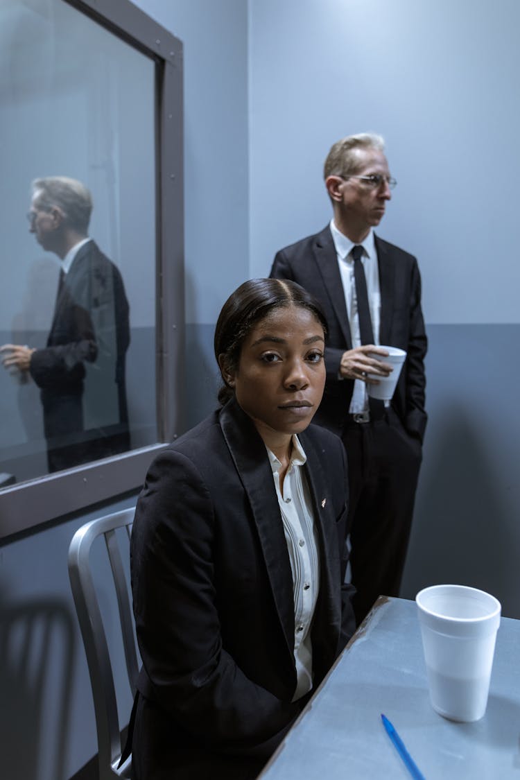 A Woman And A Man In Gray Suit Inside The Interrogation Room