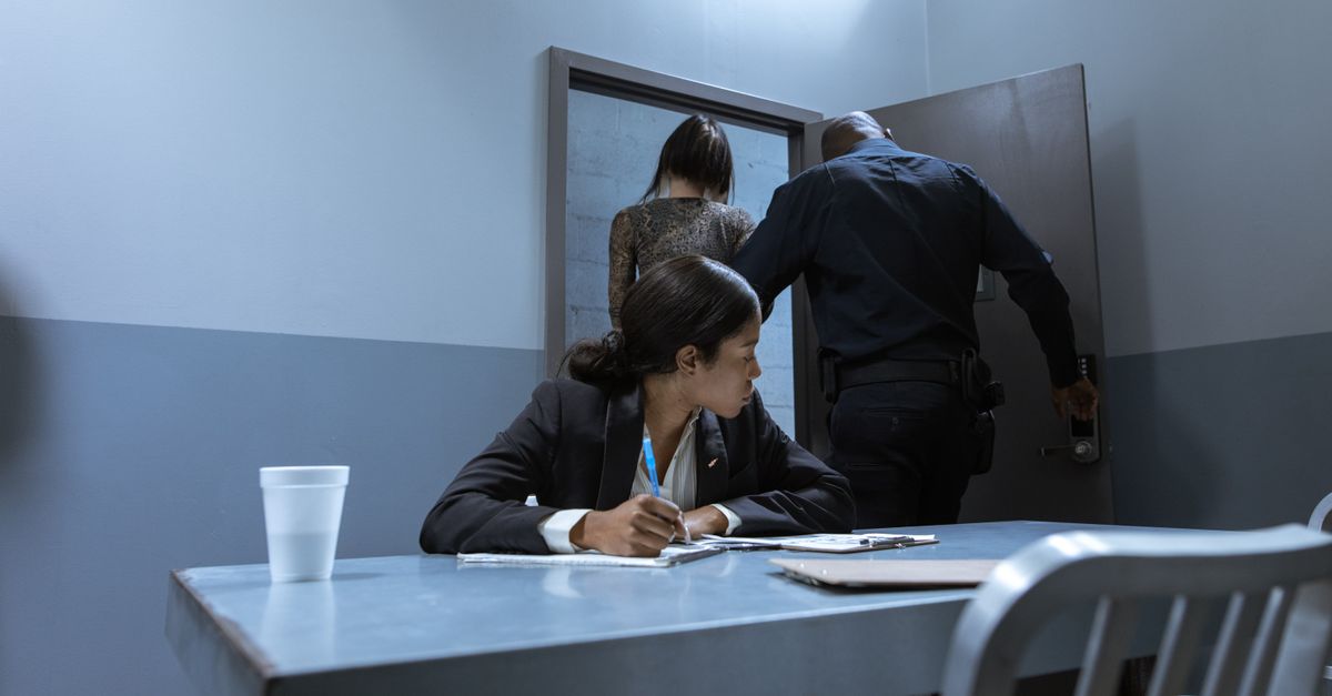 Illustration showing a person being questioned by a police officer in an interrogation room.