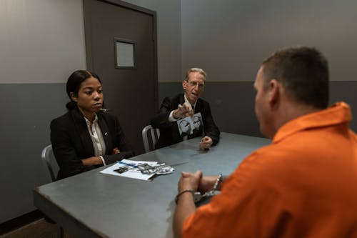 Free Cops Talking to the Criminal About the Evidence Stock Photo