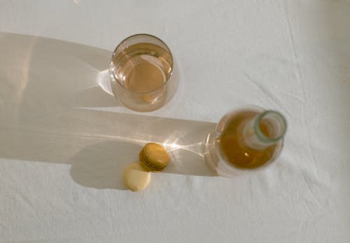 Стеклянная бутылка возле съедобных макарон на столе