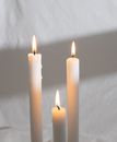 Burning candles against white textile