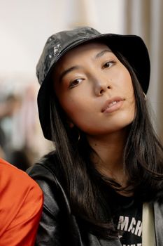 Stylish portrait of a woman wearing a trendy bucket hat, exuding elegance and confidence.