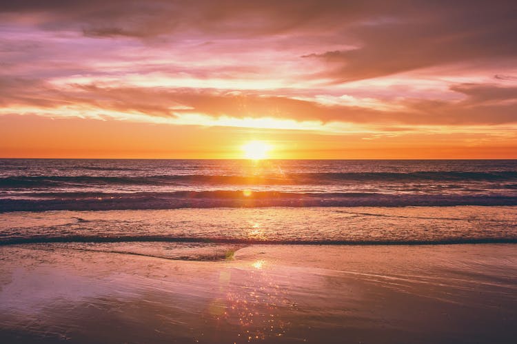 Sea Waves Crashing On Shore During Sunset