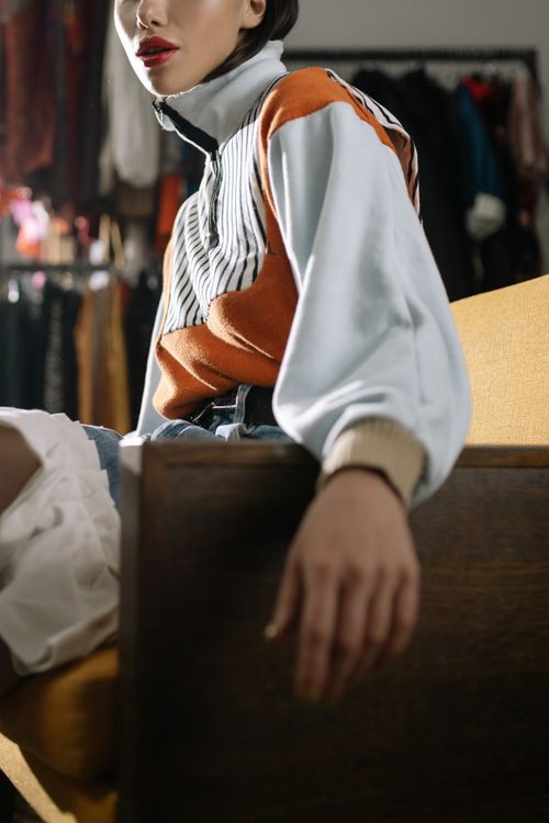 Free Stylish woman in trendy outfit sitting indoors, showcasing a modern fashion look. Stock Photo