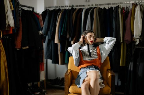 Free A stylish female model sits in a retro wardrobe setup. Stock Photo