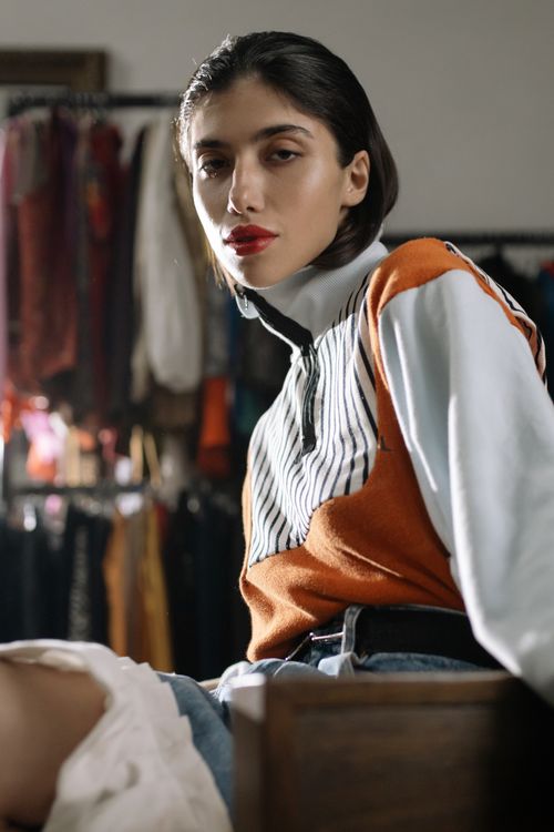 Free Fashionable woman poses indoors in a vibrant turtleneck sweater, exuding style and elegance. Stock Photo