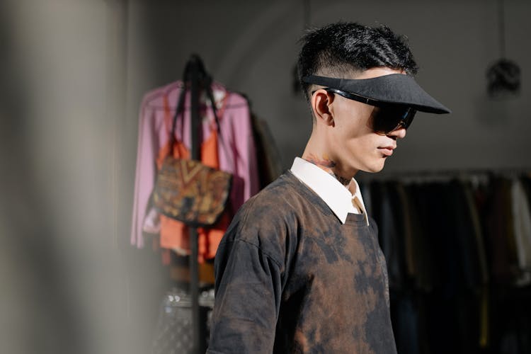 Man In Black And Brown Long Sleeve Shirt Wearing Black Sunglasses With Black Sun Visor Hat