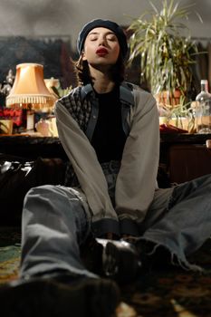 Fashionable woman wearing a beret, posing casually among vintage decor and soft lighting.