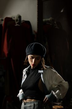 Fashionable woman in a black beret and stylish outfit exuding a retro vibe indoors.
