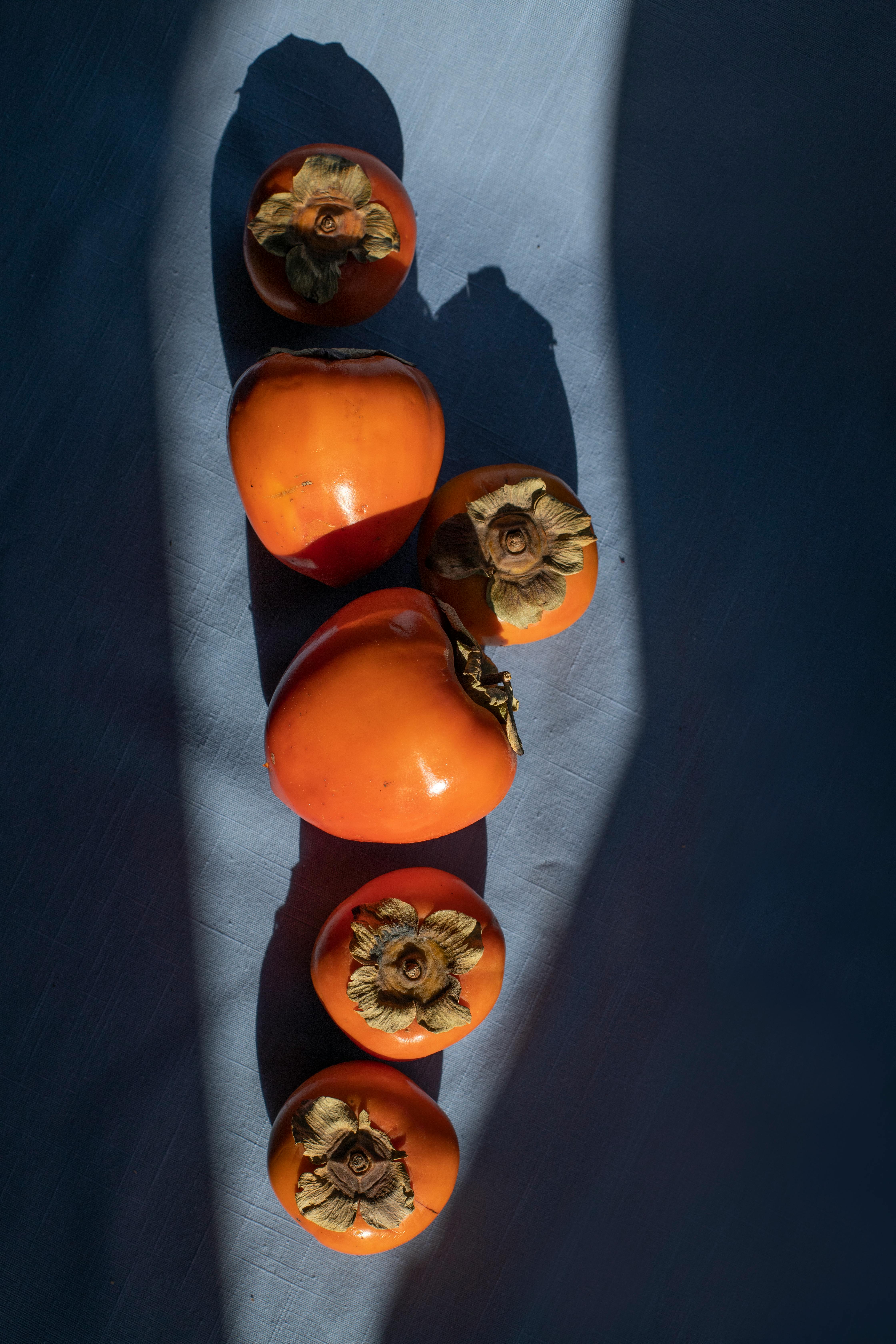 delicious persimmons heaped on blue surface