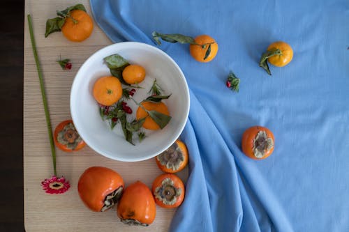 Composition of sweet persimmons and mandarins placed on table