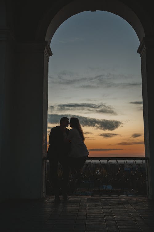 Unrecognizable couple caressing against sunset sky