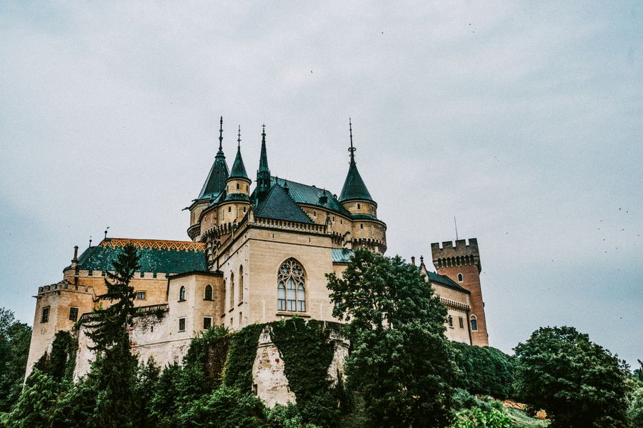 Věže a štíty Bojnického zámku nad korunami stromů
