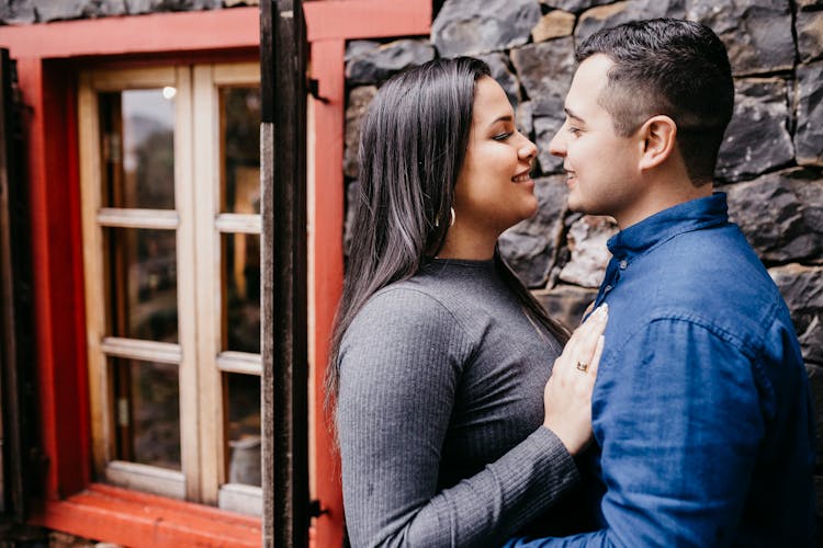 Smiling Multiracial Couple Standing Close Near Old House