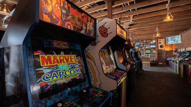 A row of vintage arcade machines in a retro-styled gaming room with dim lighting.