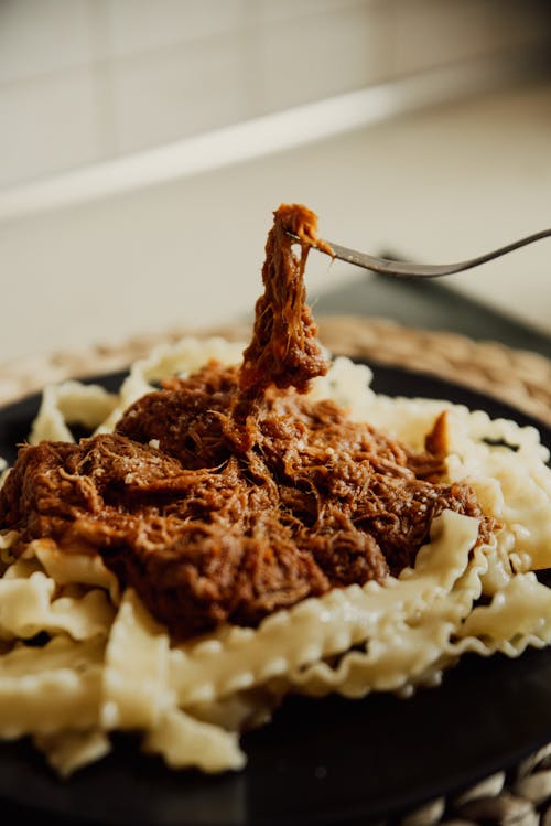 A Plate of Pulled Pork on Top of a Pasta