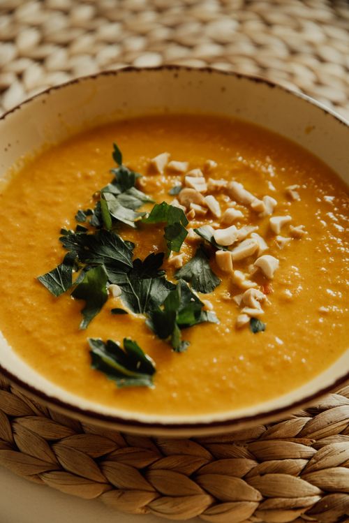 Free Warm and inviting pumpkin soup garnished with herbs and nuts, perfect for a cozy meal. Stock Photo