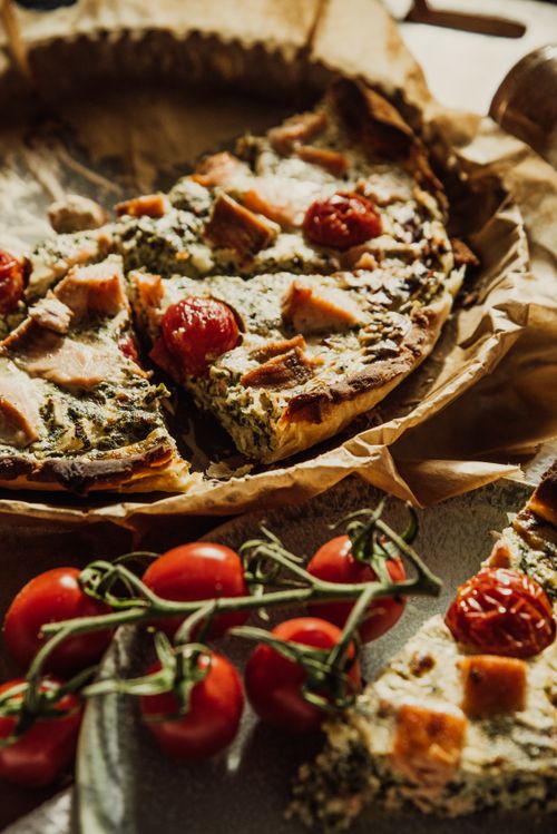 Free Delicious homemade spinach and cherry tomato quiche, beautifully styled on a rustic table. Stock Photo