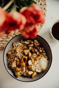 Delicious vegan breakfast bowl with oatmeal, nuts, and fruits, perfect for a healthy meal.
