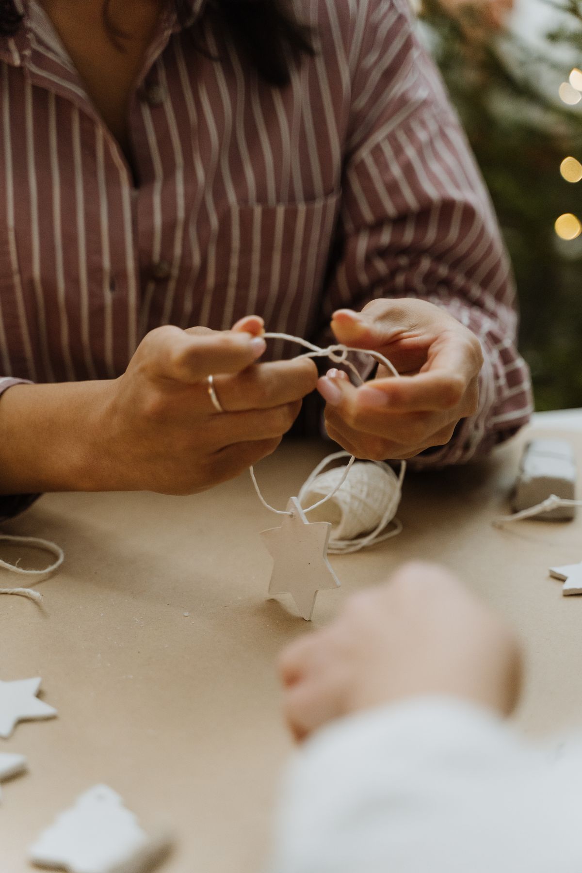 Hands preparing handmade Christmas star ornaments with glue and glitter