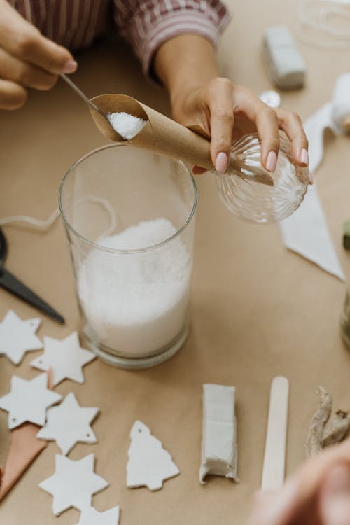 Woman Pouring Fake Snow in Transparent Bauble