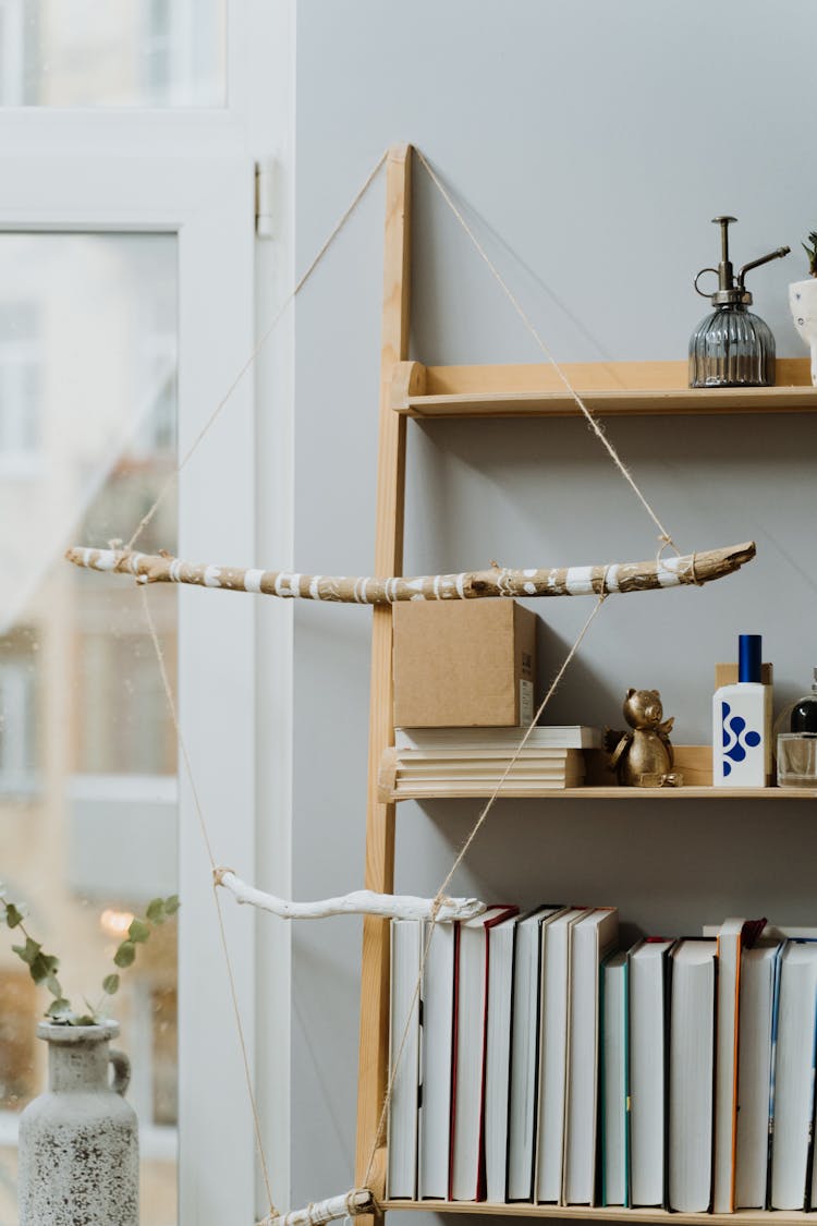 Wooden Decoration With String Hanging On Bookshelf