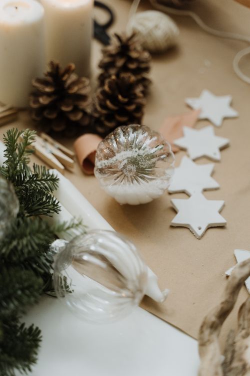 Free A cozy arrangement of Christmas decorations featuring pine cones, baubles, and white stars on a rustic background. Stock Photo