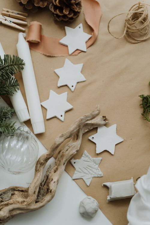 Free A flat lay of Christmas decorations featuring stars, candles, and natural elements for a cozy holiday setting. Stock Photo