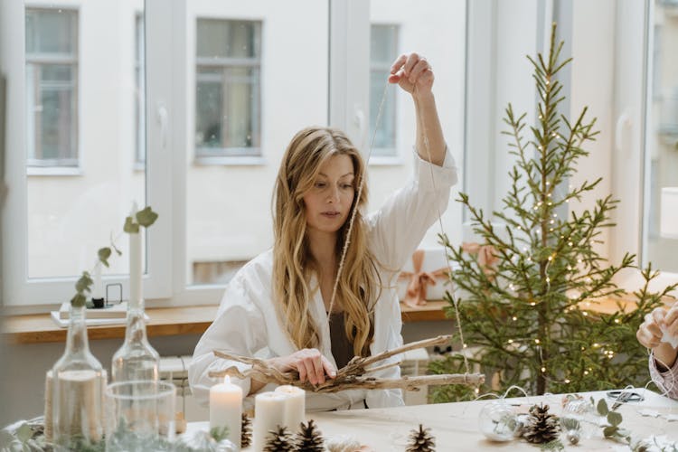 Blonde Woman Decorating Branch For Christmas