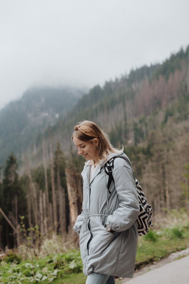 Woman In Gray Jacket Walking Down The Road