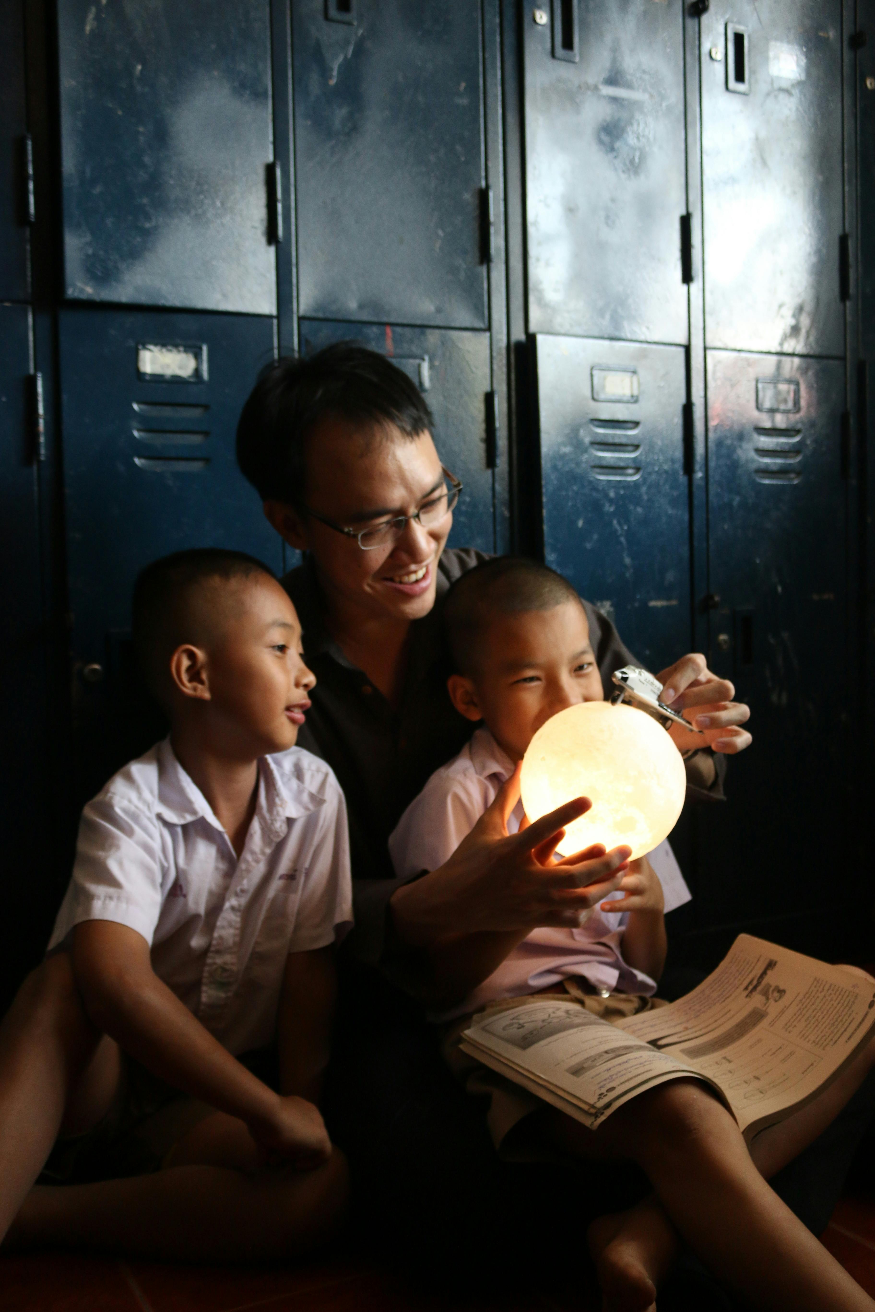 cheerful asian dad with children and shiny lamp