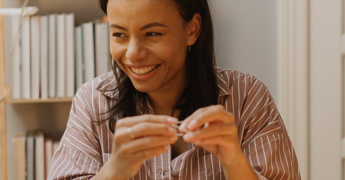 A joyful woman creating homemade holiday decorations in a cozy indoor setting, surrounded by crafting materials.