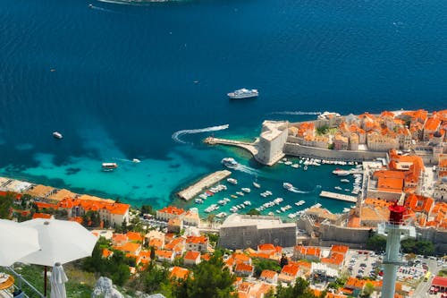 Aerial View of City Buildings and Marina Near Blue Sea