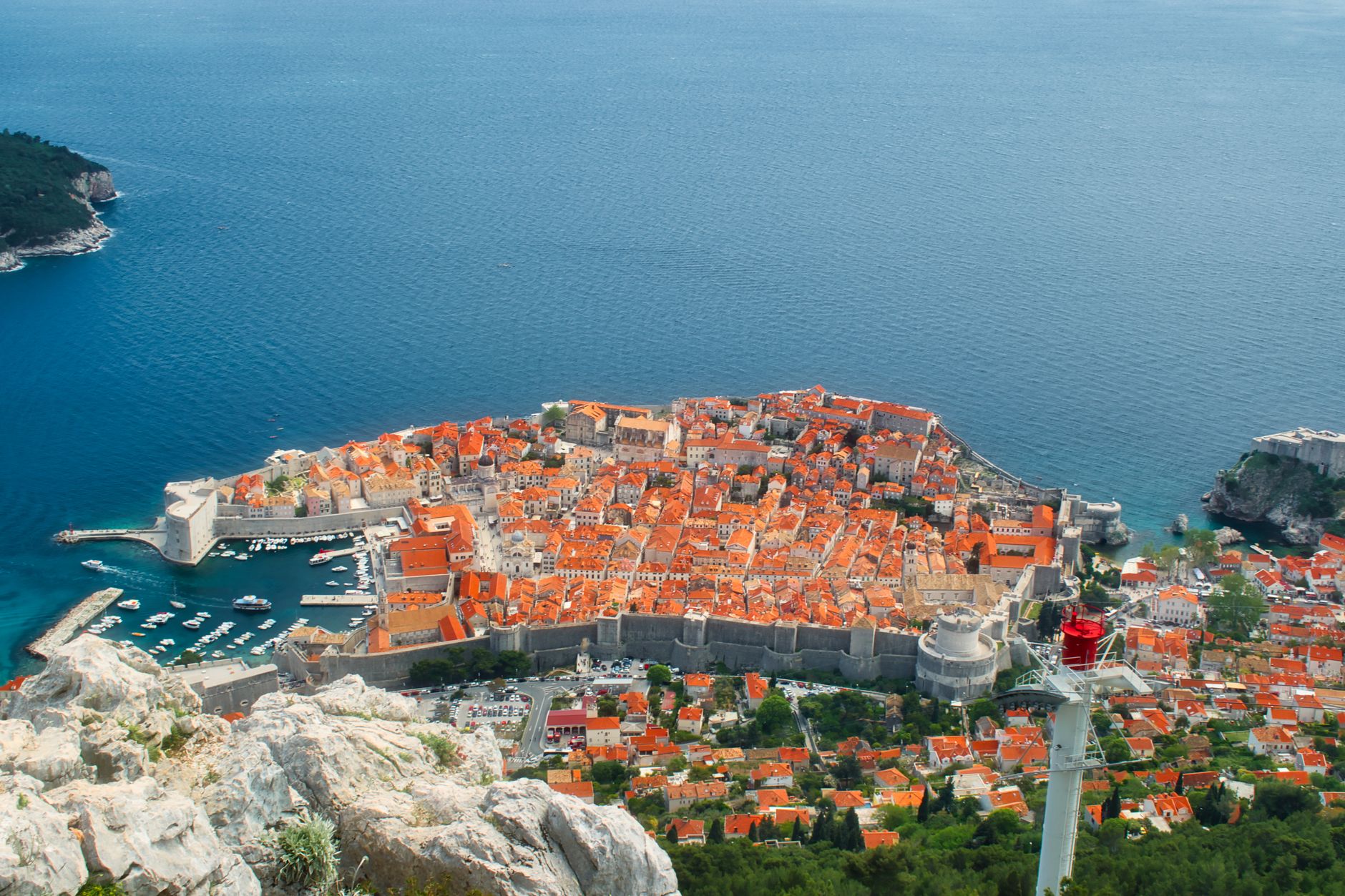 Tourists dragging suitcases up steep steps near Ploče Gate at midday