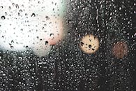 窗户上的雨滴被艺术捕捉，背景是模糊的光散景